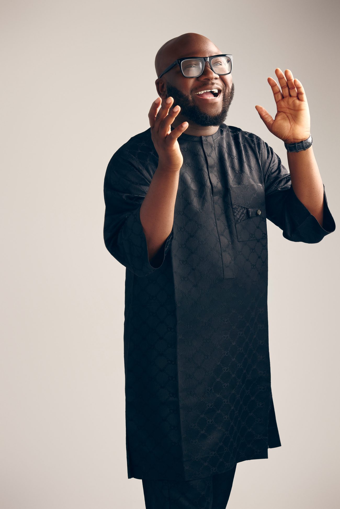 Victor Akinde singing with both hands raised